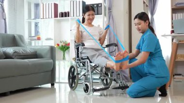 Asyalı kadın doktor yaşlı kadın hastalarla ilgilenir, fizik tedaviye yardım eder, lastik tüplerle esnetir, ve sağlık, danışmanlık ve egzersiz için diz ağrısı, spor yaralanmaları,.