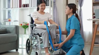 Asyalı kadın doktor yaşlı kadın hastalarla ilgilenir, fizik tedaviye yardım eder, lastik tüplerle esnetir, ve sağlık, danışmanlık ve egzersiz için diz ağrısı, spor yaralanmaları,.