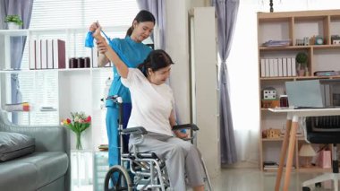 Asyalı kadın doktor yaşlı kadın hastalarla ilgilenir, fizik tedaviye yardım eder, lastik tüplerle esnetir, ve sağlık, danışmanlık ve egzersiz için diz ağrısı, spor yaralanmaları,.