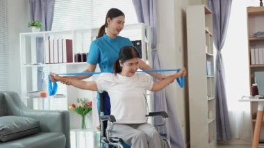 Asyalı kadın doktor yaşlı kadın hastalarla ilgilenir, fizik tedaviye yardım eder, lastik tüplerle esnetir, ve sağlık, danışmanlık ve egzersiz için diz ağrısı, spor yaralanmaları,.