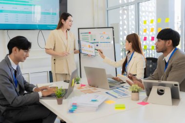 Profesyonel bir ekip, bir ofis konferans odasında gerçekleşen toplantı sırasında stratejik planlama ve karar verme süreçlerine ilişkin verileri analiz etmek üzere mali tabloları gözden geçiriyor ve birlikte çalışıyor..