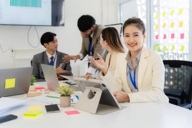 Profesyonel bir ekip, bir ofis konferans odasında gerçekleşen toplantı sırasında stratejik planlama ve karar verme süreçlerine ilişkin verileri analiz etmek üzere mali tabloları gözden geçiriyor ve birlikte çalışıyor..