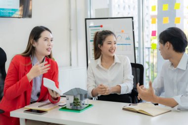Asyalı kadın emlakçı anlaşmayı açıklıyor ve yeni bir ev almak üzere olan çifte emlak satışı için ev sahibiyle görüşüyor..