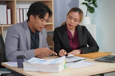 İşadamı ve kadın dizüstü bilgisayar ve belgeler kullanarak projede birlikte çalışıyorlar. İş adamları belgeleri inceliyor, mali raporları okuyor, konuşuyor, dizüstü bilgisayarlarda birlikte çalışıyor..