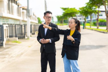 Proje yöneticisi, köy emlak şirketindeki yol yapım çalışmalarının ilerlemesini kontrol etmek için asistanına danışıyor..