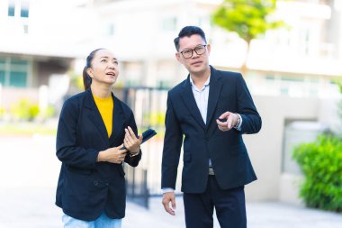 Proje yöneticisi, köy emlak şirketindeki yol yapım çalışmalarının ilerlemesini kontrol etmek için asistanına danışıyor..