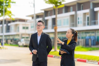 Proje yöneticisi, köy emlak şirketindeki yol yapım çalışmalarının ilerlemesini kontrol etmek için asistanına danışıyor..