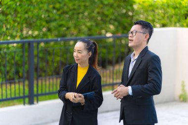 Proje yöneticisi, köy emlak şirketindeki yol yapım çalışmalarının ilerlemesini kontrol etmek için asistanına danışıyor..