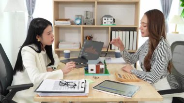 Asyalı bir emlakçı kadın iş sözleşmesini açıklasın, kiralama, satın alma, ipotek, kredi, veya bir iş kadınına sigorta.