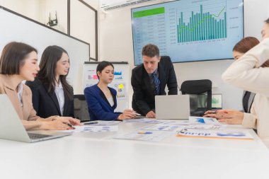 Asyalı iş adamlarından oluşan bir grup, verimli toplantı sırasında çizelge ve grafikleri analiz ediyor, takım çalışması ve işbirliği, finansal iş konsepti gösteriyorlar..