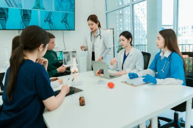 Tıp konseyi veya klinik toplantısı sırasında masada oturan meslektaşlar birlikte çalışan beyaz laboratuvar önlüklü tıp uzmanları hasta tedavi sonuçları hakkında toplantılarda konuşurlar.