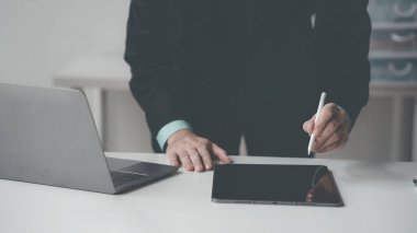 Ciddi işadamları internetteki mali raporları incelerken verileri analiz etmek için tablet ve dizüstü bilgisayar kullanıyorlar. çevrimiçi iş fikirleri