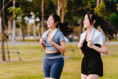 Parkta egzersiz yapan iki Asyalı kız, sağlık konsepti..