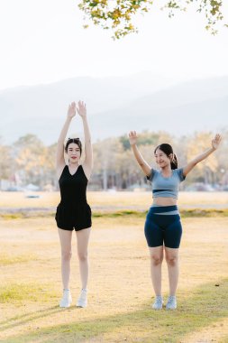 Parkta egzersiz yapan iki Asyalı kız, sağlık konsepti..