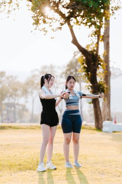Parkta egzersiz yapan iki Asyalı kız, sağlık konsepti..