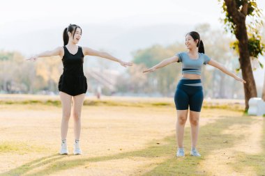 Parkta egzersiz yapan iki Asyalı kız, sağlık konsepti..