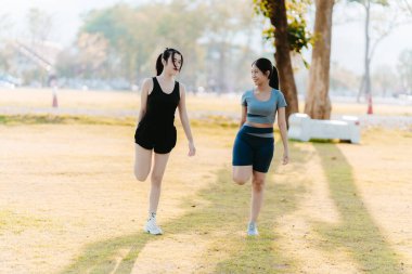 Parkta egzersiz yapan iki Asyalı kız, sağlık konsepti..