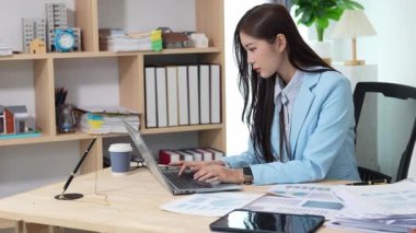 Asyalı bayan emlakçı müşterilere internet üzerinden danışmanlık hizmeti sunar müşteriye bir ev ya da dairenin içini tarif eder. Çevrimiçi ev satışı danışmanı