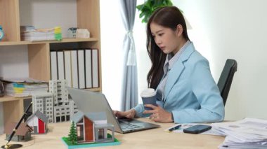 Asyalı bayan emlakçı müşterilere internet üzerinden danışmanlık hizmeti sunar müşteriye bir ev ya da dairenin içini tarif eder. Çevrimiçi ev satışı danışmanı