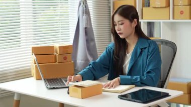 Asyalı iş kadını Küçük İş Girişimcisi, İnternet ile Evde KOBİ İş Genç kadın mutlu hissediyor ve çevrimiçi iş dünyasından siparişleri kontrol etmekten hoşlanıyor