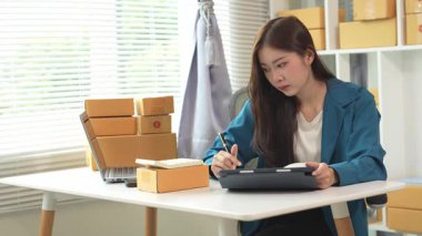 Asyalı iş kadını Küçük İş Girişimcisi, İnternet ile Evde KOBİ İş Genç kadın mutlu hissediyor ve çevrimiçi iş dünyasından siparişleri kontrol etmekten hoşlanıyor