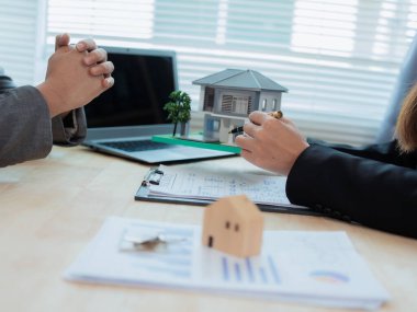 Ev ve arazi satın alacak bir emlak şirketi, ev satın alma anlaşması ve kredi sözleşmesini kabul ettikten sonra ev ve anahtarları müşteriye teslim ediyor. Yakın plan fotoğraf.