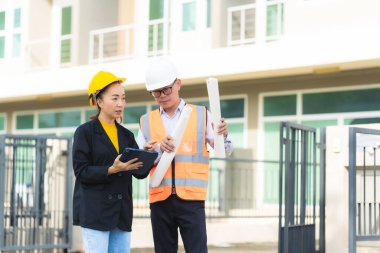 Emlakçı ya da yönetici inşaat alanı projesiyle ilgili dijital tabletle proje planını tartışıyor