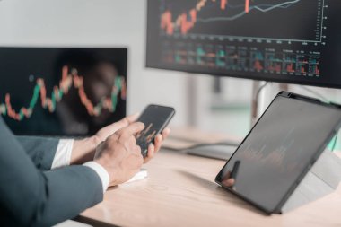 İşadamı, finansal tablet ve dizüstü bilgisayarla finansal tabletleri analiz ederek bilgisayardaki büyüme grafiklerini analiz ediyor. Yakın vadeli borsa büyümesine yönelik yatırım stratejileri