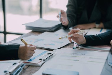 Takımlar proje stratejisi üzerinde çalışır, raporları hazırlar, konferans masasındaki bilgi grafiklerine işaret ederler. Satış sonuçlarını analiz et piyasa araştırması yap, yakın plan resimler çek