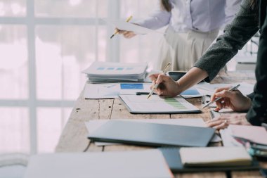Takımlar proje stratejisi üzerinde çalışır, raporları hazırlar, konferans masasındaki bilgi grafiklerine işaret ederler. Satış sonuçlarını analiz et piyasa araştırması yap, yakın plan resimler çek