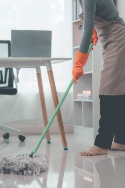 Evde bahar temizliği günü için dezenfekte spreyi sıkacak eldivenli bir ev hanımı. Kadın hijyeni ev işi.