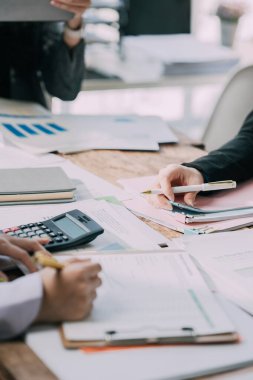 Takımlar proje stratejisi üzerinde çalışır, raporları hazırlar, konferans masasındaki bilgi grafiklerine işaret ederler. Satış sonuçlarını analiz et piyasa araştırması yap, yakın plan resimler çek