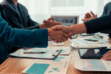 İşadamları mali tablolar, grafikler ve belgelerle el sıkışıyor, verileri analiz ettikten sonra anlaşmalar yapıyor ve uzun vadeli yatırım stratejileri planlıyorlar..