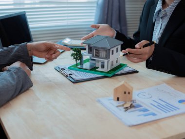 Emlakçı ofisteki detaylı ev modelini sunuyor, yakın plan emlak yatırım konseptini..