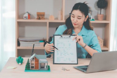 Ev satışı, Asyalı kadınlarla online istişare ahşap ev modeli, anahtar ve dokümanlar ile emlak konsepti.
