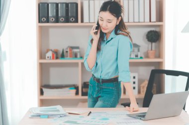 Genç Asyalı kadın muhasebeci iyi satışlar için heyecanlı ve masanızdaki satış performansınızdan memnun olduğunuzu ifade edin..