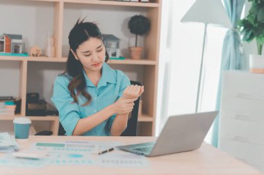 Ofis sendromundan muzdarip güzel Asyalı iş kadınının dizüstü bilgisayarla uzun süre çalıştıktan sonra boynunda, omuzlarında ve kollarında ağrı var..