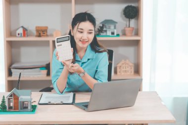 Ev satışı, Asyalı kadınlarla online istişare ahşap ev modeli, anahtar ve dokümanlar ile emlak konsepti.