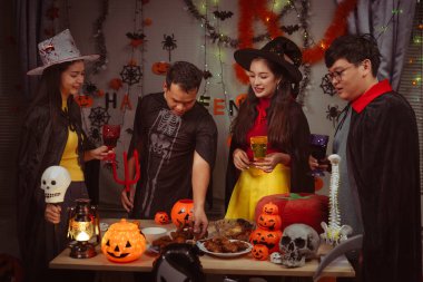 Asian man and woman celebrating Halloween, pumpkins at night, Halloween banner background for holiday activities.