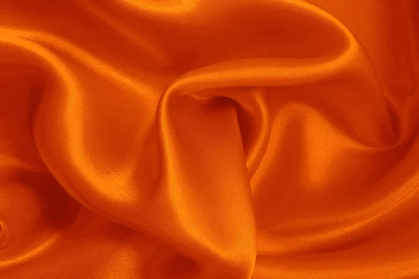 背景やデザインアート作品のためのオレンジ生地のテクスチャ シルクやリネンの美しいしわのパターン — ストック写真