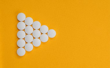 Sarı arka planda haplardan yapılmış ok. Antidepresan ve iyileşme konsepti.