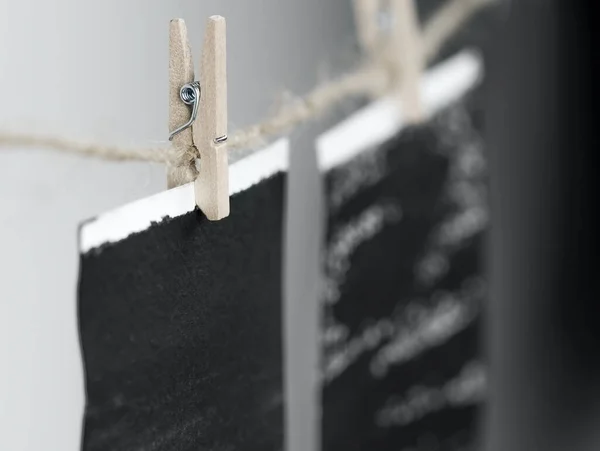 Close-up of photo frames hanging on the rope with wooden pins.