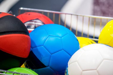 Spor salonundaki alışveriş arabasında futbol topu ve voleybol. Spor malzemeleri alışverişi.