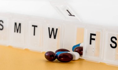 İlaç ve besin takviyeleri içeren günlük ilaç kutusu kapatılıyor.