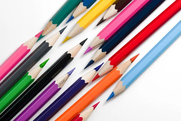 Pencils background. Colored pencils are scattered on white background. Set of bright pencils for drawing. Mock up pencil or crayons.