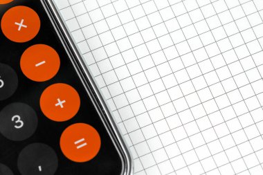 Telefon defterin üzerinde duruyor. Yakın plan. Eğitim konsepti. Çalışma masasında boş beyaz sayfa