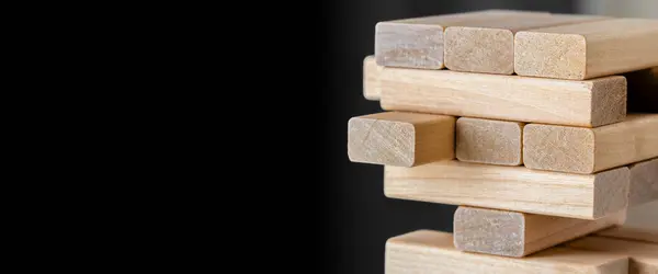 Wooden blocks tower with copy space on black background.