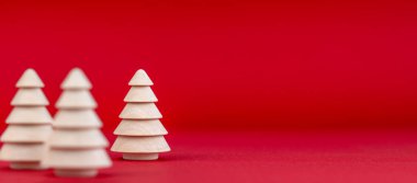 Christmas background in vintage style. Wooden Christmas Trees Decoration on a Red Background with Soft Shadow. Merry Christmas. clipart