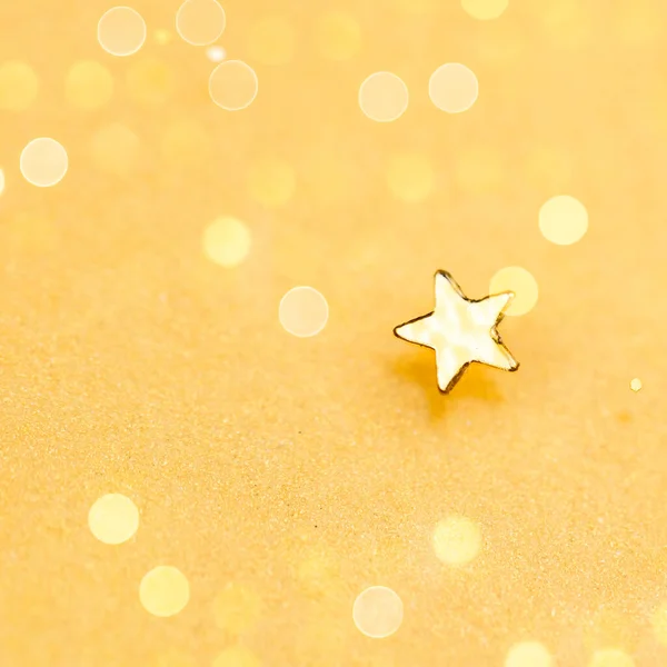 Gold Bokeh Decoration. Gold Star on Glowing Gold Background.