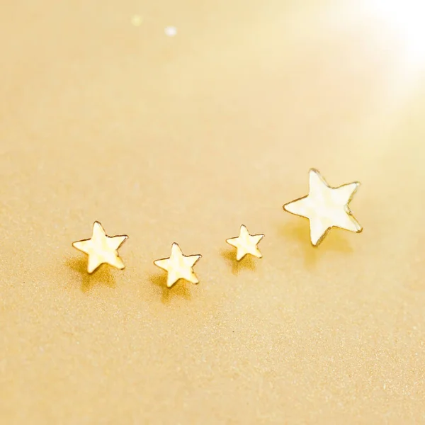 Christmas Golden Stars on Shiny Gold Background. Festive sparkling lights. Golden Sparkling Falling Stars With Stardust Trail.